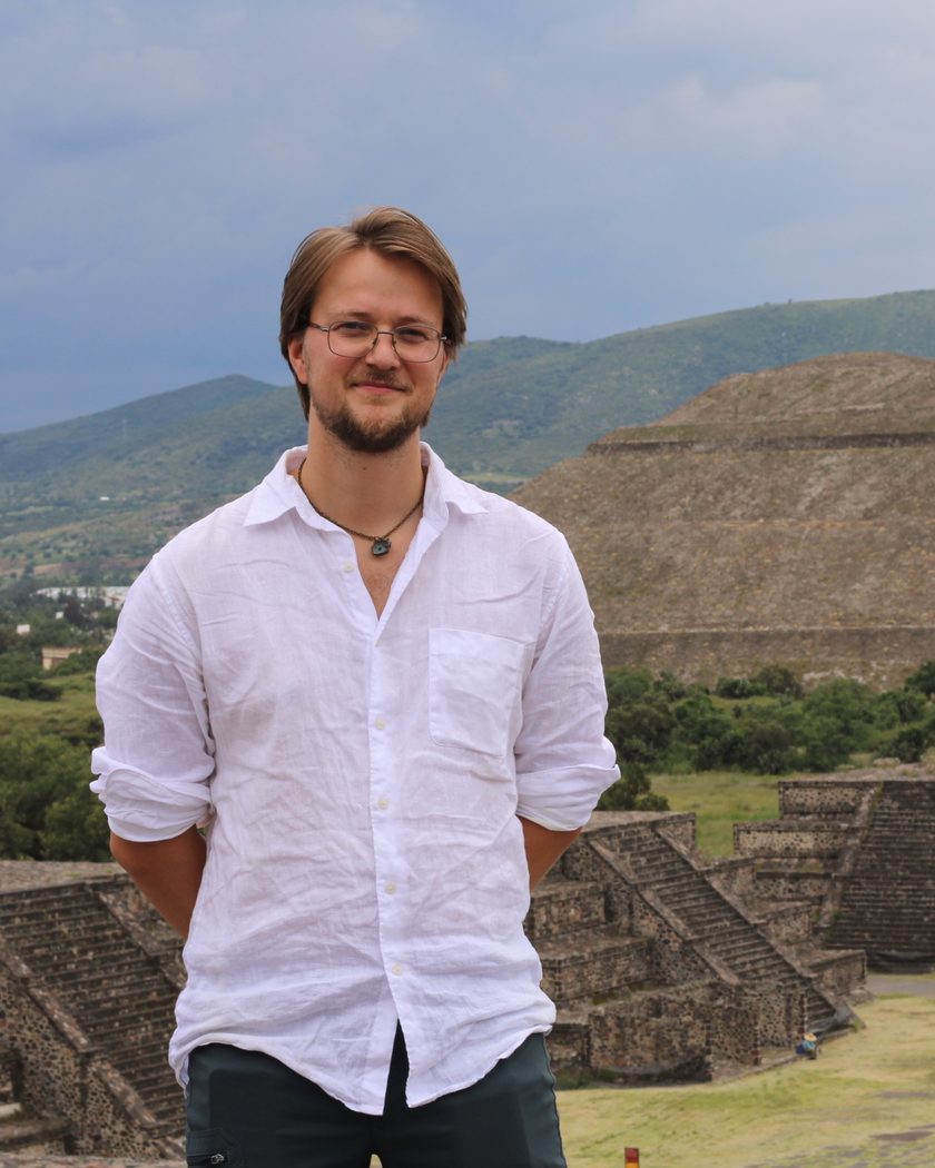 Thor, smiling, in a white linen shirt in front of the Pyramid of the Sun